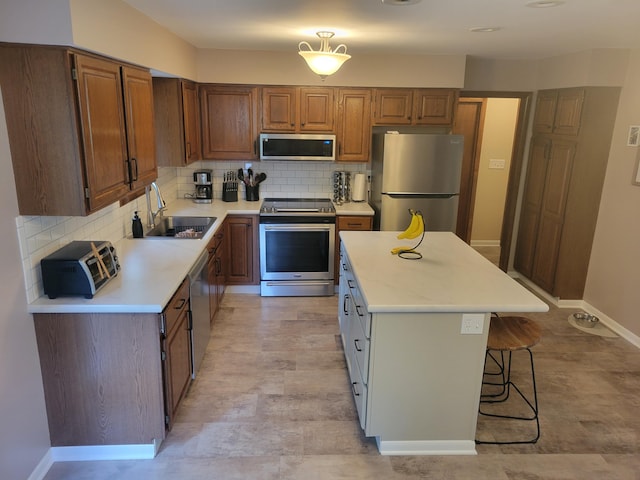 1200 Elmwood Dr, Jenison, MI 49428 - kitchen featuring stainless steel appliances, light countertops, backsplash, and a breakfast bar