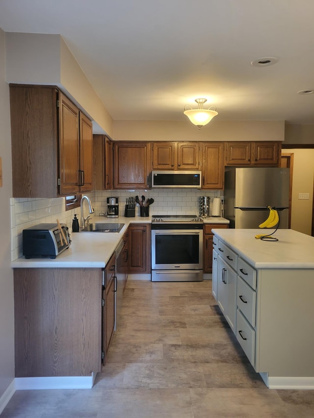 1200 Elmwood Dr, Jenison, MI 49428 - kitchen with appliances with stainless steel finishes, ventilation hood, light countertops, decorative backsplash, and brown cabinetry