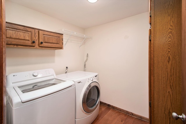 1200 Elmwood Dr, Jenison, MI 49428 - laundry room featuring washer and dryer, wood finished floors, and cabinet space
