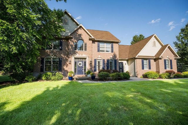9095 Marsh Cir, Galesburg, MI 49053 - view of front of property with brick siding, a front lawn, and roof with shingles