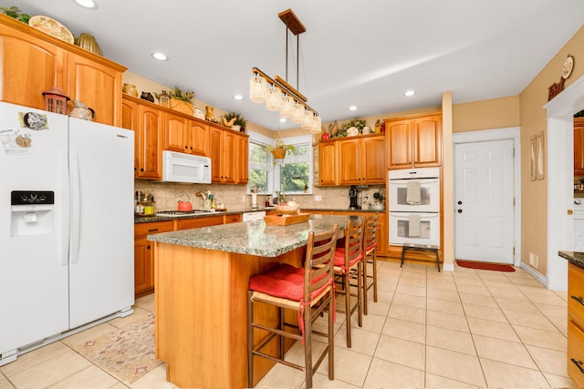 9095 Marsh Cir, Galesburg, MI 49053 - kitchen featuring white appliances, a kitchen island, decorative backsplash, dark stone counters, and light tile patterned floors