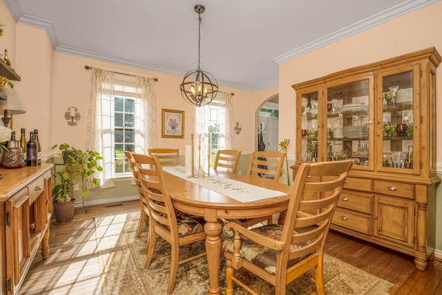 9095 Marsh Cir, Galesburg, MI 49053 - dining area featuring light wood-style floors, arched walkways, plenty of natural light, ornamental molding, and a chandelier
