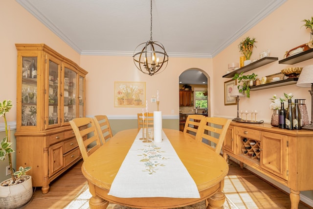 9095 Marsh Cir, Galesburg, MI 49053 - dining area with arched walkways, light wood-type flooring, ornamental molding, and a chandelier