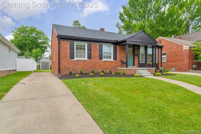 4607 Robinwood Ave, Royal Oak, MI 48073 - view of front facade featuring brick siding, a front lawn, a chimney, and a storage shed