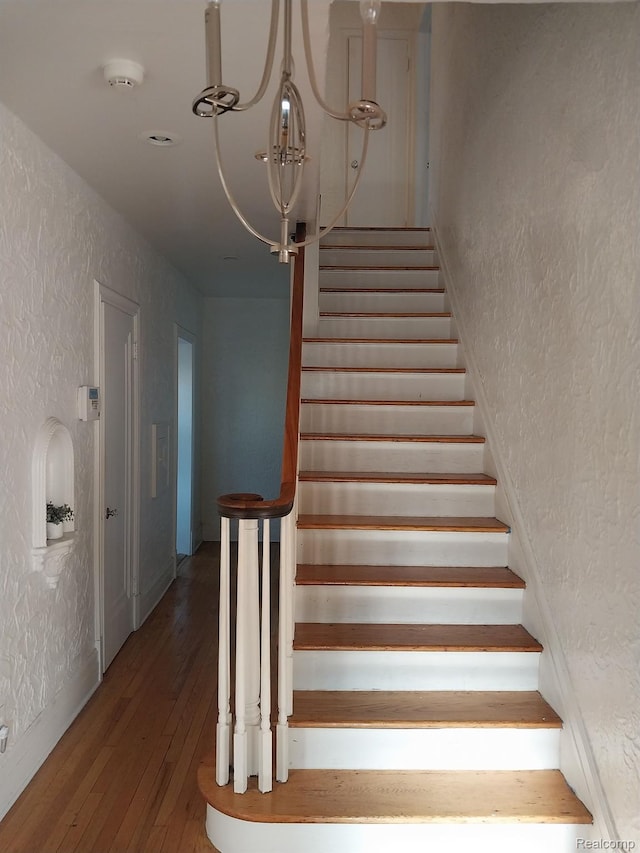 16834 Muirland St, Detroit, MI 48221 - stairs featuring a textured wall, hardwood / wood-style floors, and a chandelier