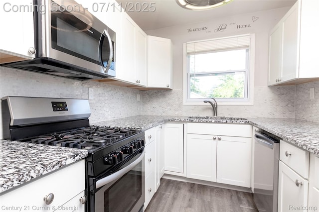 29046 S Wesley Ave, Flat Rock, MI 48134 - kitchen featuring appliances with stainless steel finishes, white cabinetry, light stone countertops, and light wood-style flooring