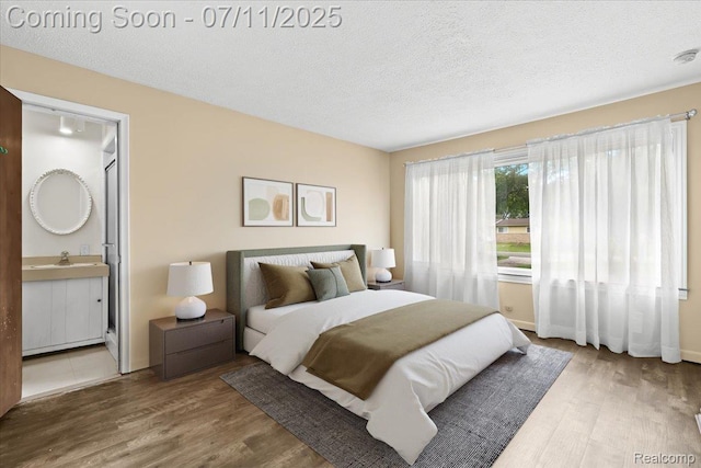 21840 N Tuller Ct, Southfield, MI 48076 - bedroom featuring wood finished floors, a textured ceiling, and connected bathroom