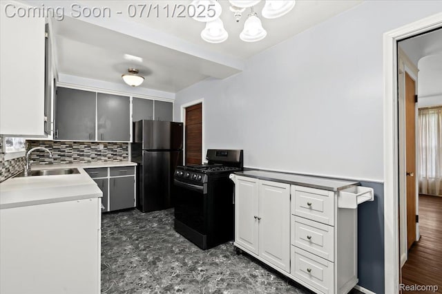 21840 N Tuller Ct, Southfield, MI 48076 - kitchen featuring freestanding refrigerator, black gas range oven, a chandelier, decorative backsplash, and gray cabinetry