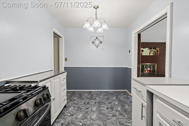 21840 N Tuller Ct, Southfield, MI 48076 - kitchen featuring gas range oven, white cabinetry, a chandelier, and pendant lighting