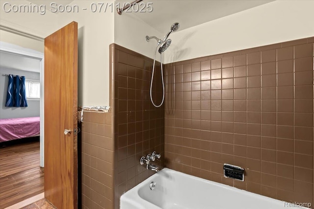 21840 N Tuller Ct, Southfield, MI 48076 - ensuite bathroom with shower / bath combination, wood finished floors, tile walls, and a wainscoted wall