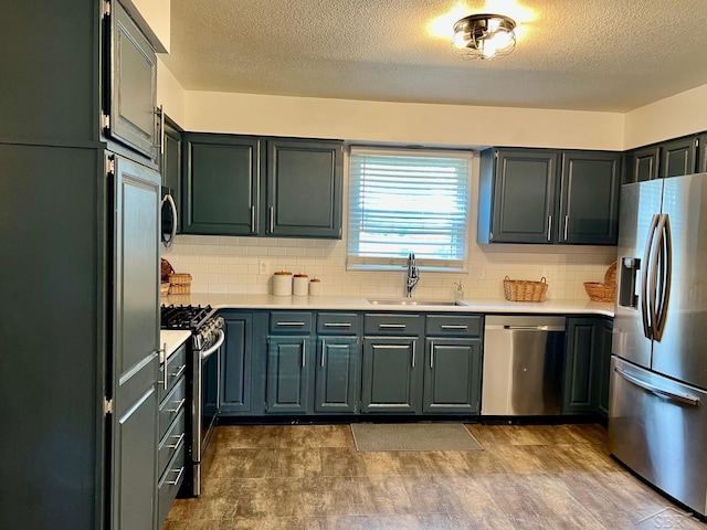 4865 Cactus Dr, Saginaw, MI 48603 - kitchen with stainless steel appliances, light countertops, decorative backsplash, and a textured ceiling