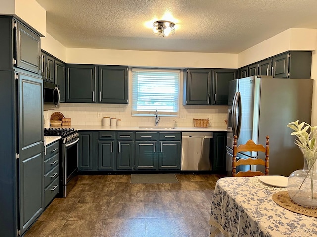 4865 Cactus Dr, Saginaw, MI 48603 - kitchen with appliances with stainless steel finishes, light countertops, backsplash, and a textured ceiling