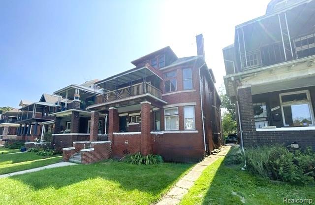 2471-2473 Lothrop St, Detroit, MI 48206 - view of front facade with a front lawn and brick siding