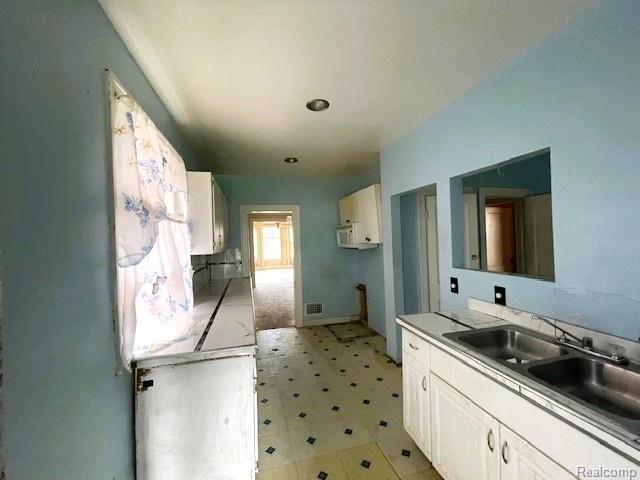 2471-2473 Lothrop St, Detroit, MI 48206 - kitchen featuring light flooring and white cabinetry