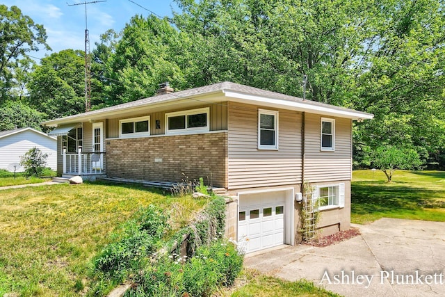 1460 N Peterson Rd, Muskegon, MI 49445 - view of front of property with a garage, a front lawn, a chimney, concrete driveway, and brick siding