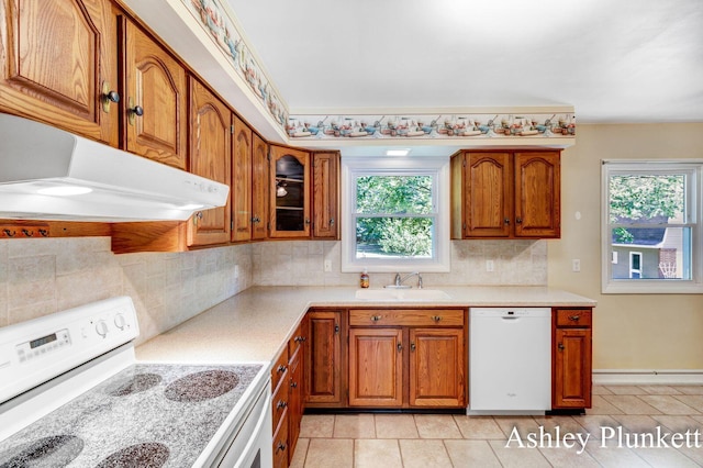 1460 N Peterson Rd, Muskegon, MI 49445 - kitchen with white appliances, brown cabinetry, and plenty of natural light