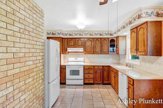 1460 N Peterson Rd, Muskegon, MI 49445 - kitchen featuring white appliances, under cabinet range hood, brown cabinetry, light countertops, and decorative backsplash