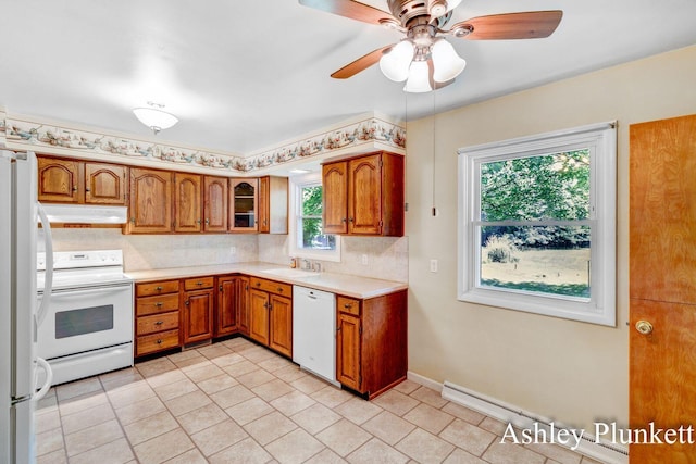 1460 N Peterson Rd, Muskegon, MI 49445 - kitchen with white appliances, under cabinet range hood, brown cabinetry, and light countertops