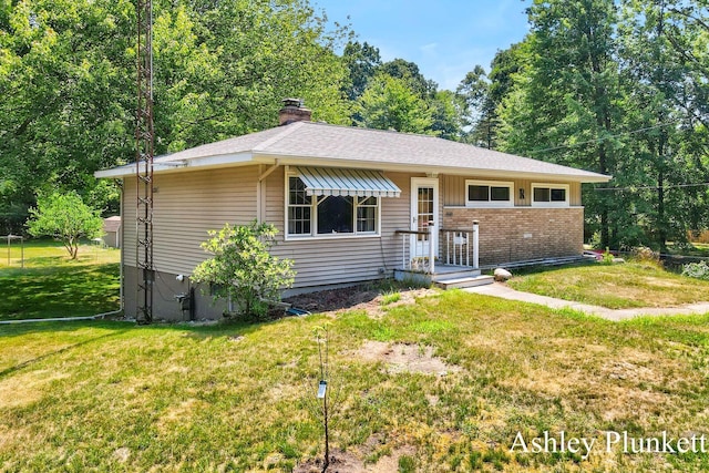 1460 N Peterson Rd, Muskegon, MI 49445 - view of front of home featuring a front lawn, brick siding, and a chimney
