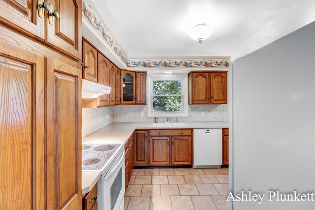 1460 N Peterson Rd, Muskegon, MI 49445 - kitchen with white appliances, light countertops, brown cabinetry, and decorative backsplash