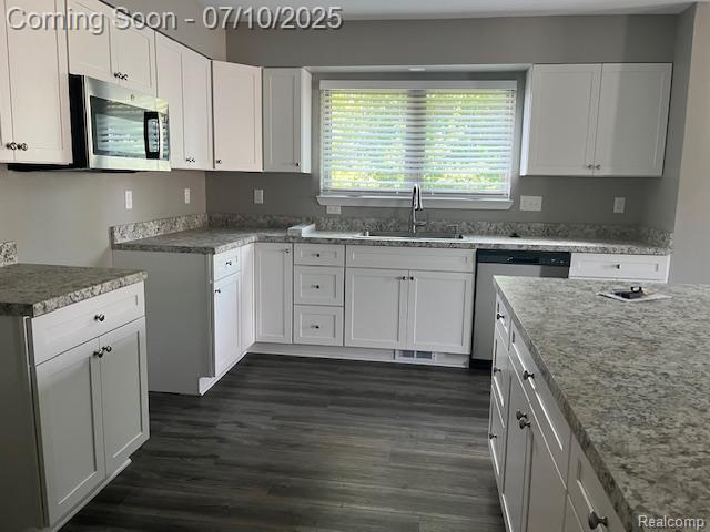 9351 Rayna Dr, Davison, MI 48423 - kitchen with appliances with stainless steel finishes, light stone counters, white cabinets, and dark wood-type flooring