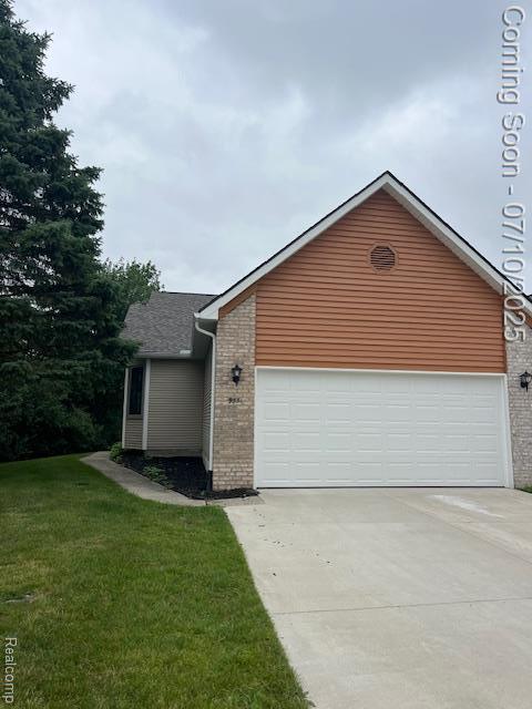 9351 Rayna Dr, Davison, MI 48423 - view of front facade with brick siding, driveway, a front lawn, and an attached garage