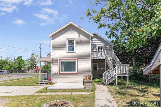 1002 Madison St, Grand Haven, MI 49417 - view of front of house featuring stairs, a front yard, and a wooden deck