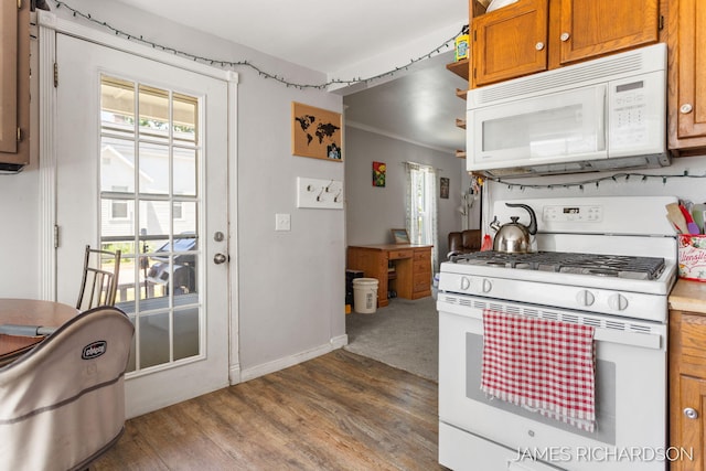 1002 Madison St, Grand Haven, MI 49417 - kitchen with white appliances, wood finished floors, brown cabinets, and crown molding