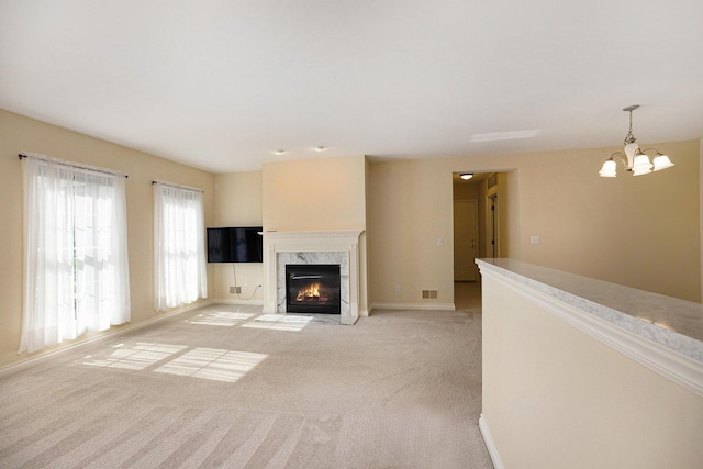 5724 Hampshire Ln, Ypsilanti, MI 48197 - unfurnished living room with light colored carpet, a chandelier, and a premium fireplace