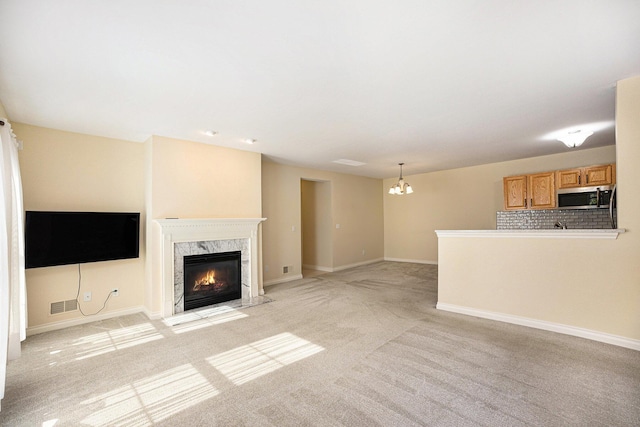 5724 Hampshire Ln, Ypsilanti, MI 48197 - unfurnished living room featuring a premium fireplace, light carpet, and a chandelier