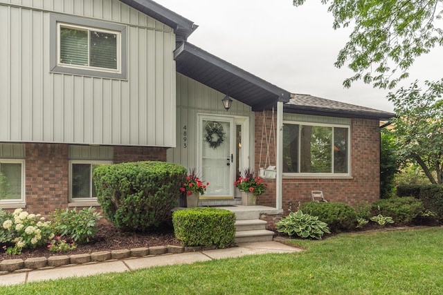 4893 Club Pl, Ypsilanti, MI 48197 - view of front of home featuring brick siding, board and batten siding, a front lawn, and a shingled roof