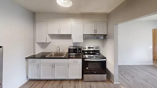 101 E Mckay St, Saline, MI 48176 - kitchen featuring stainless steel appliances, under cabinet range hood, light wood-style flooring, white cabinetry, and dark countertops
