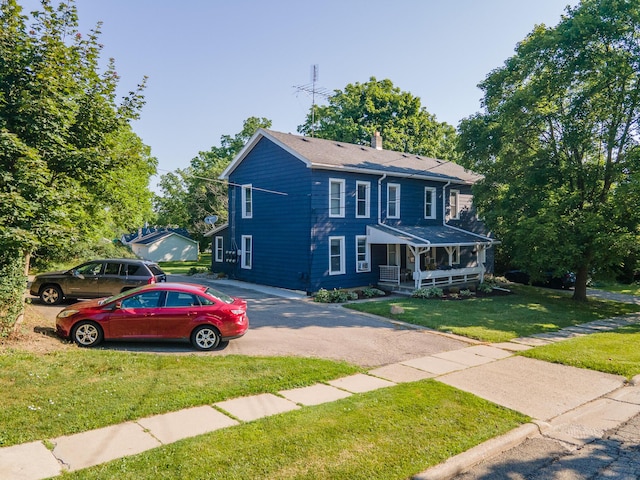 101 E Mckay St, Saline, MI 48176 - colonial house featuring covered porch, a front yard, a chimney, and driveway