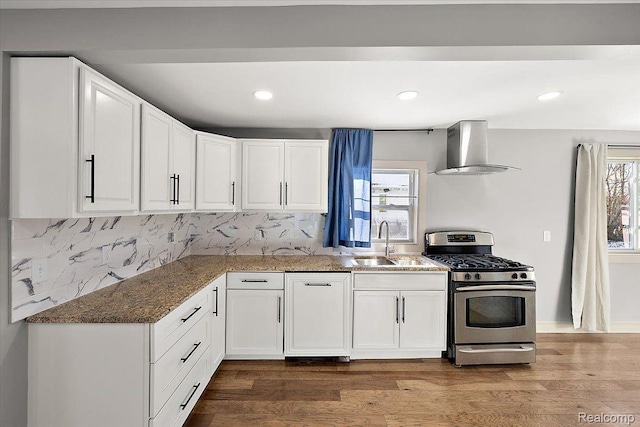 20817 Parkside Blvd, Ferndale, MI 48220 - kitchen with gas stove, wall chimney range hood, dark stone countertops, white cabinets, and recessed lighting