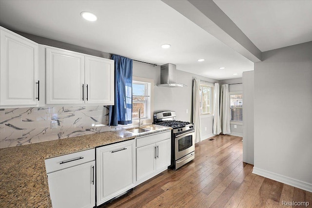 20817 Parkside Blvd, Ferndale, MI 48220 - kitchen with stainless steel range with gas stovetop, wall chimney range hood, light stone counters, white cabinetry, and hardwood / wood-style flooring