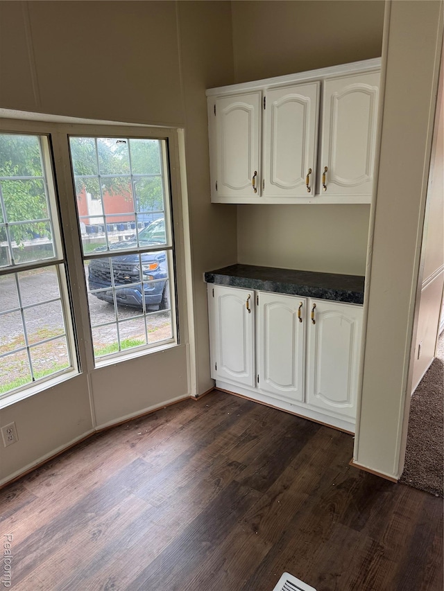 2445 E Grand River Ave, Lot, Williamston, MI 48895 - unfurnished dining area featuring dark wood-style flooring and baseboards