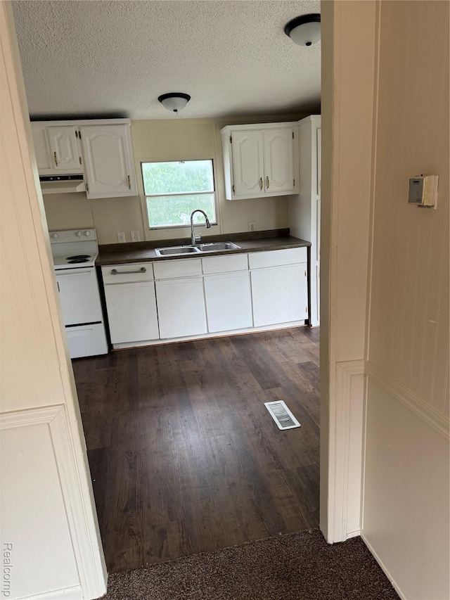 2445 E Grand River Ave, Lot, Williamston, MI 48895 - kitchen featuring white electric range, under cabinet range hood, dark countertops, white cabinetry, and a textured ceiling