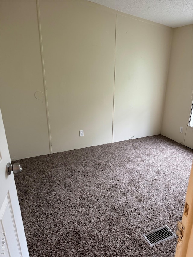 2445 E Grand River Ave, Lot, Williamston, MI 48895 - carpeted empty room with a textured ceiling