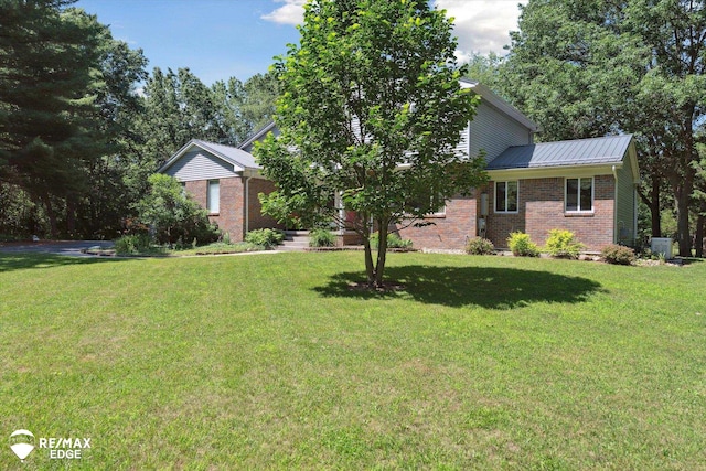 416 State Park Rd, Ortonville, MI 48462 - view of front of property with brick siding, a front yard, and a metal roof