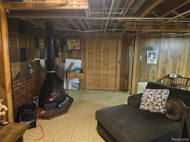 17328 Mcnamara Dr, Garden City, MI 48152 - basement featuring wood walls, a wood stove, and tile patterned floors