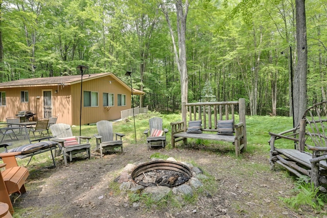 5154 Cherry Rd, Farwell, MI 48622 - view of yard featuring an outdoor fire pit and a wooded view