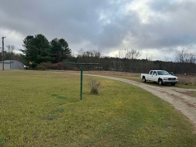 524 S Cherry St, Evart, MI 49631 - view of green lawn featuring driveway