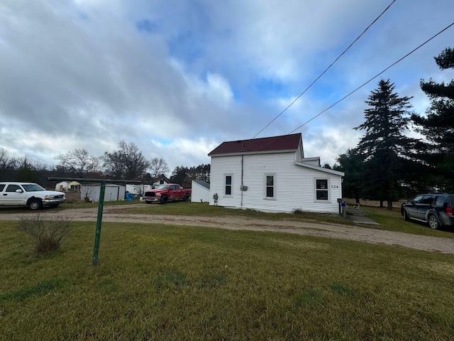 524 S Cherry St, Evart, MI 49631 - view of property exterior featuring driveway and a yard