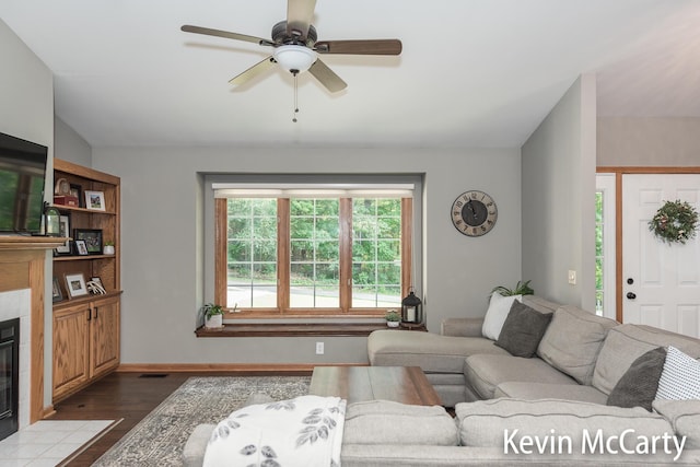 530 Pine Haven Dr, Comstock Park, MI 49321 - living room featuring a tiled fireplace, dark wood finished floors, a ceiling fan, and lofted ceiling