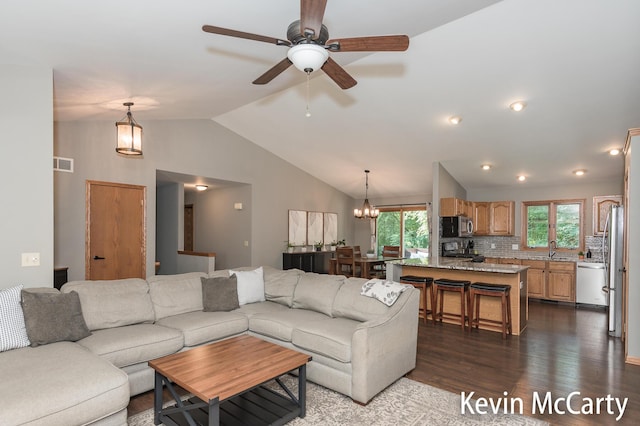 530 Pine Haven Dr, Comstock Park, MI 49321 - living room with dark wood-style flooring, vaulted ceiling, a chandelier, and ceiling fan