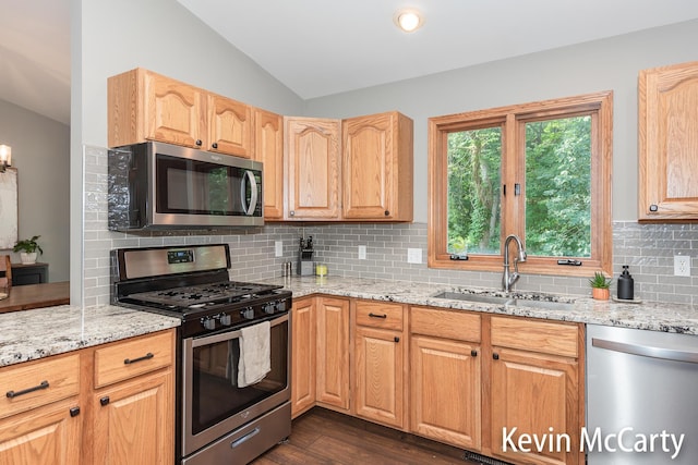 530 Pine Haven Dr, Comstock Park, MI 49321 - kitchen featuring stainless steel appliances, lofted ceiling, light stone countertops, decorative backsplash, and dark wood-style flooring