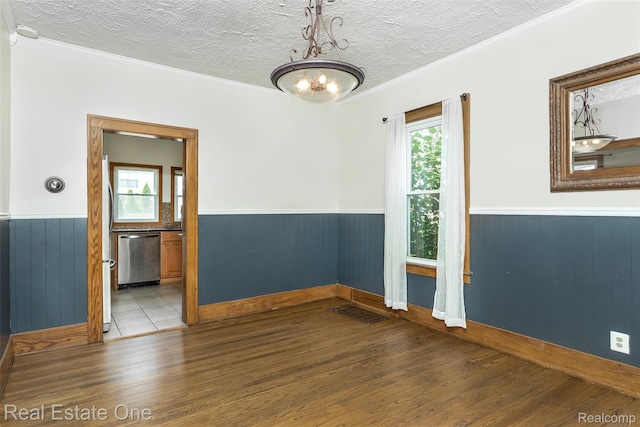 14711 Borgman St, Oak Park, MI 48237 - empty room with wood finished floors, a wainscoted wall, a textured ceiling, ornamental molding, and a chandelier
