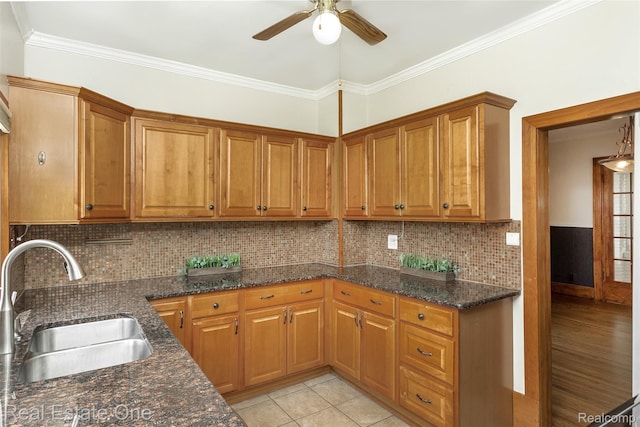 14711 Borgman St, Oak Park, MI 48237 - kitchen featuring ceiling fan, brown cabinetry, dark stone countertops, ornamental molding, and backsplash