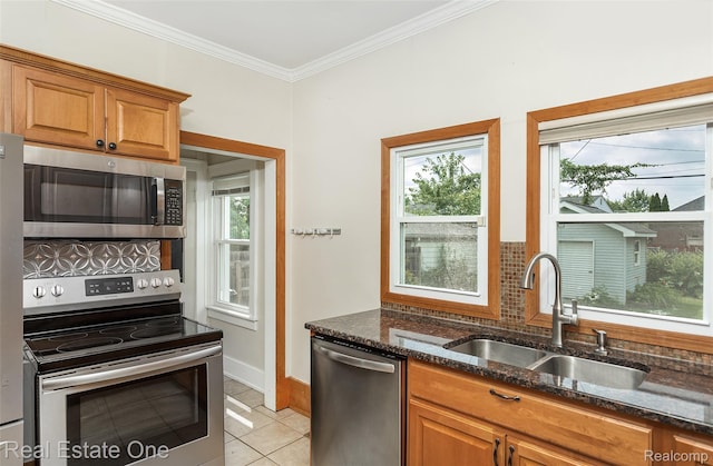 14711 Borgman St, Oak Park, MI 48237 - kitchen with appliances with stainless steel finishes, dark stone counters, light tile patterned floors, crown molding, and tasteful backsplash