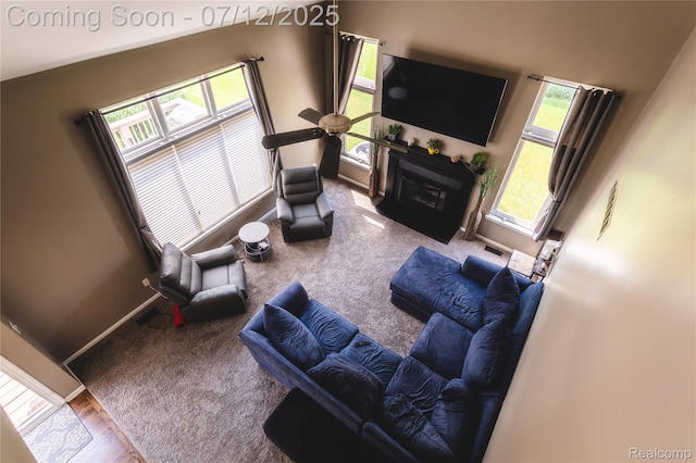 6020 Majestic Oaks Dr, Commerce Twp, MI 48382 - living room featuring a glass covered fireplace, carpet flooring, and wood finished floors